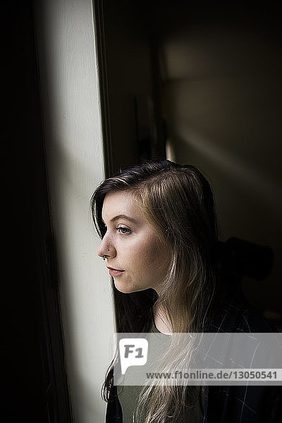 Close-up of thoughtful woman standing by window
