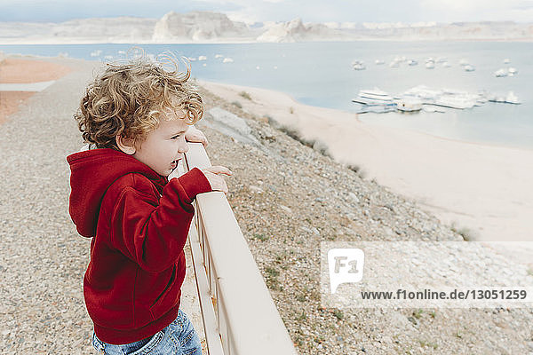 Side view of boy looking at Lake Powell while standing by railing
