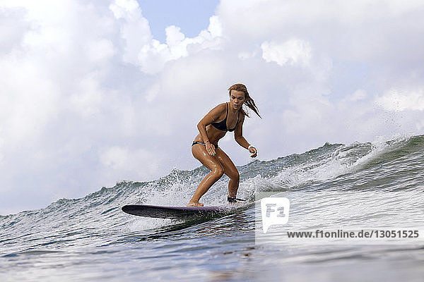 Frau surft auf Wellen im Meer