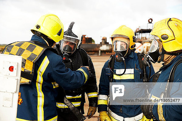 Ausbildung von Feuerwehrleuten  Feuerwehrleute mit Atemschutzgerät  die dem Vorgesetzten zuhören