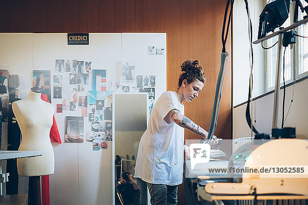 Fashion designer ironing in her work studio