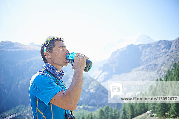Wanderer  der aus der Wasserflasche trinkt  Mont Cervin  Matterhorn  Wallis  Schweiz