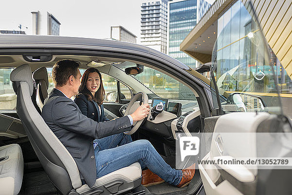 Man and woman sitting in electric car Manchester UK