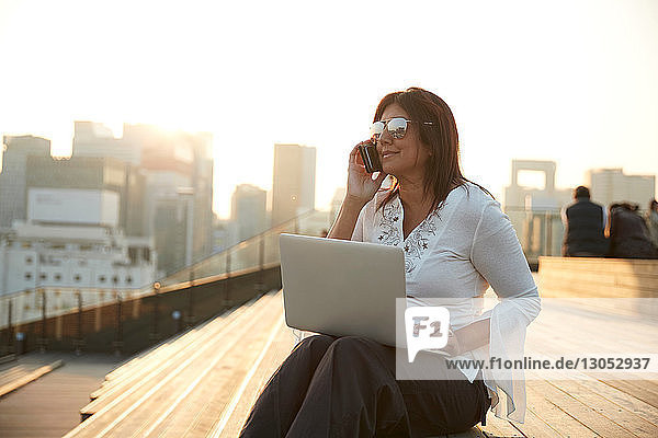 Geschäftsfrau mit Laptop und Smartphone auf der Treppe  Seoul  Südkorea