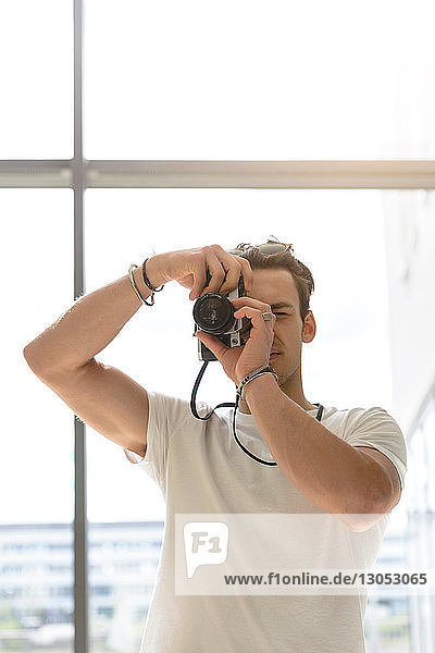 Mann beim Fotografieren  Glaswand im Hintergrund