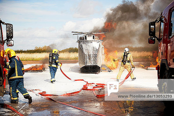 Ausbildung von Feuerwehrleuten  Team von Feuerwehrleuten löscht Scheinhubschrauberfeuer in der Ausbildungsstätte