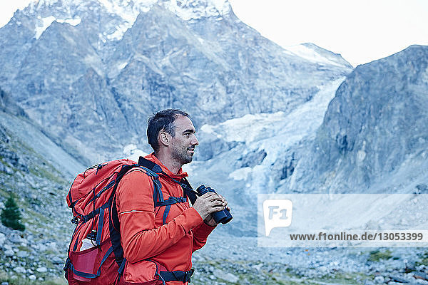 Hiker using binoculars  Mont Cervin  Matterhorn  Valais  Switzerland