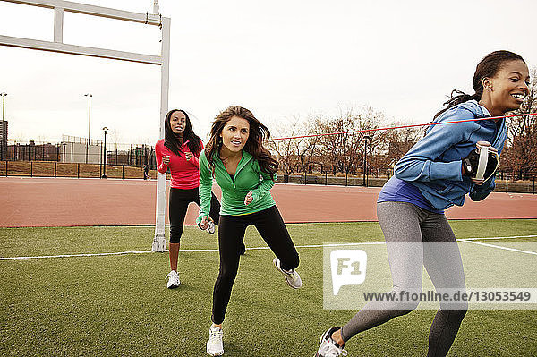 Sportlerinnen trainieren auf dem Spielfeld bei klarem Himmel