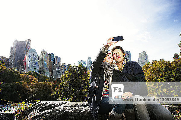 Happy couple taking selfie in Central Park on sunny day