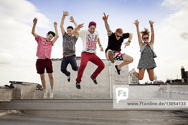 Aufgeregte Freunde springen auf Gebäudeterrasse