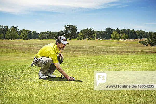 Side view of man playing golf on grassy field