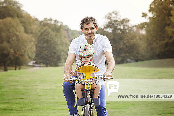 Vater mit Tochter beim Fahrradfahren im Park