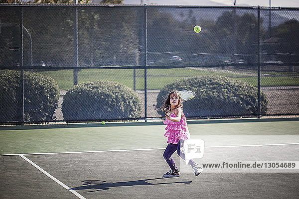 Girl looking up while playing tennis on court
