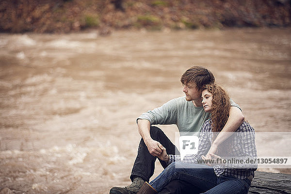 Couple relaxing at riverbank