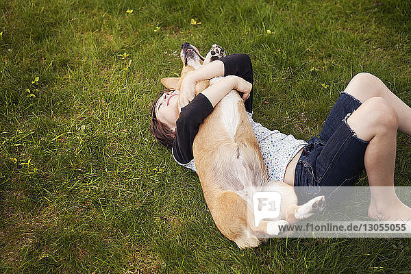 High angle view of girl playing with dog in yard