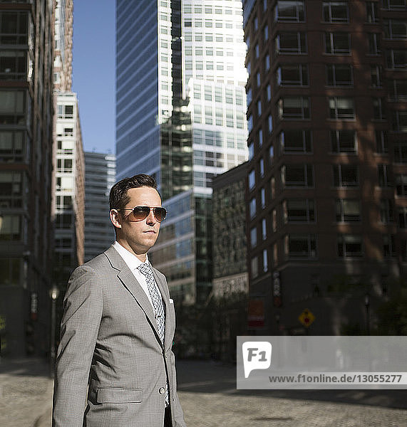 Young businessman standing on street in city