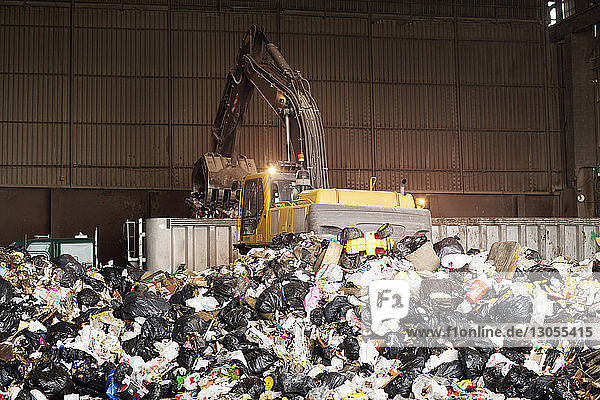 Kran sammelt Müll in Recycling-Anlage