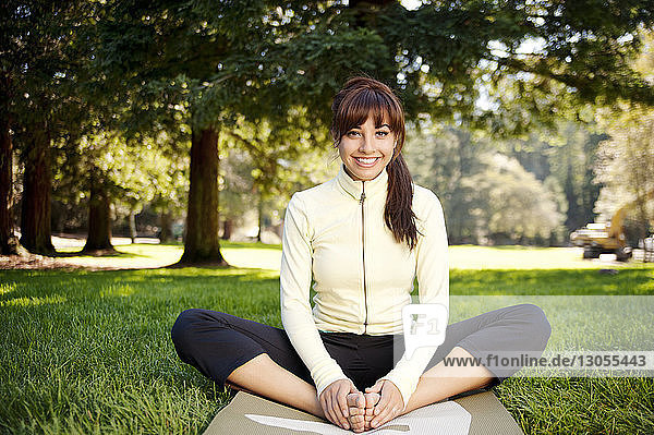 Portrait of happy woman practicing yoga at park