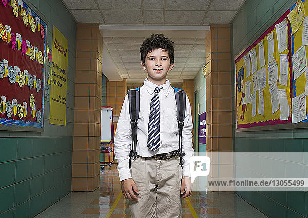 Portrait of schoolboy standing in corridor