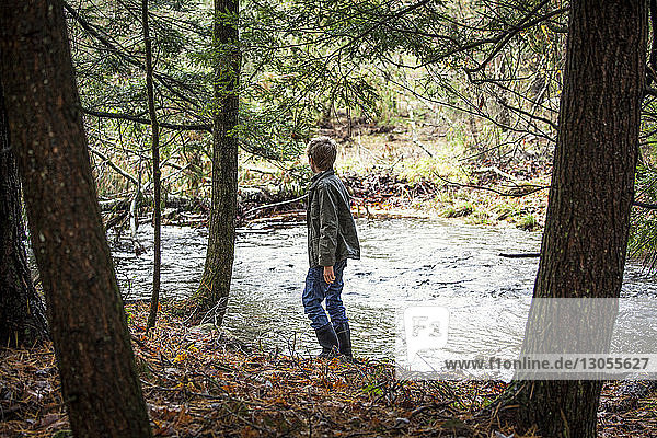 Side view of boy standing by river
