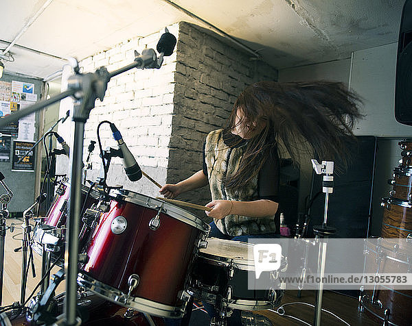 Glückliche Frau genießt es  zu Hause Schlagzeug zu spielen