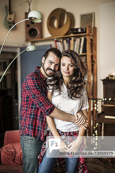 Portrait of young couple standing at home
