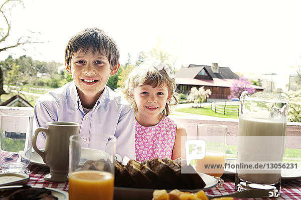 Portrait of siblings sitting at table during breakfast