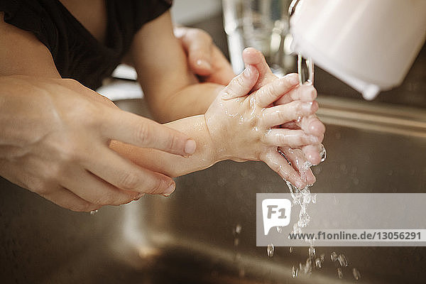 Nahaufnahme einer Mutter  die ihrer Tochter beim Händewaschen zu Hause hilft