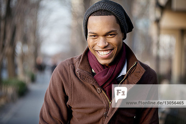 Porträt eines fröhlichen jungen Mannes mit Strickmütze