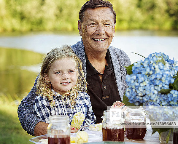 Porträt von Grossvater und Enkelin am Picknicktisch