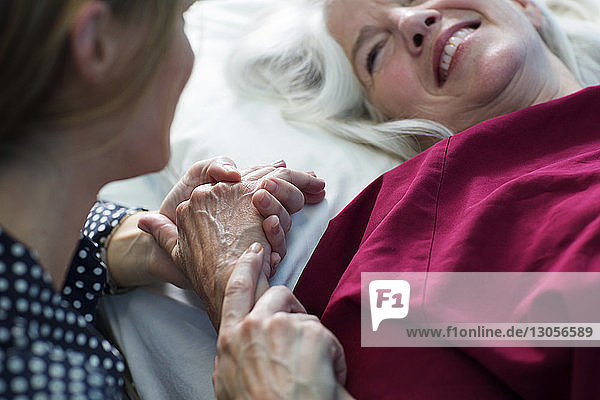 Patient hält im Krankenhaus die Hand seiner Tochter