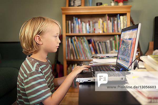 Junge benutzt Laptop-Computer zu Hause