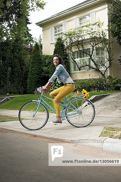 Frau schaut weg  während sie auf der Stadtstraße Fahrrad fährt
