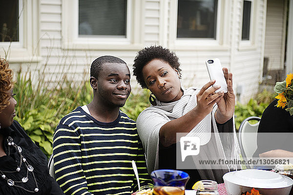 Mutter und Sohn klicken am Picknicktisch auf Selfie