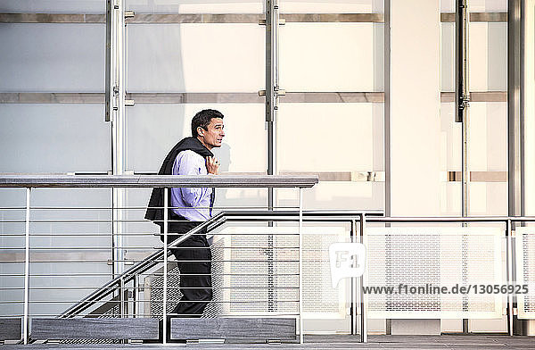 Side view of businessman standing on escalator