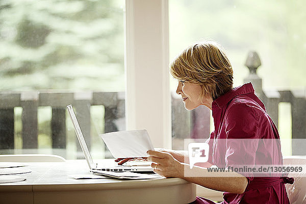 Frau benutzt Laptop-Computer für Online-Einkäufe zu Hause