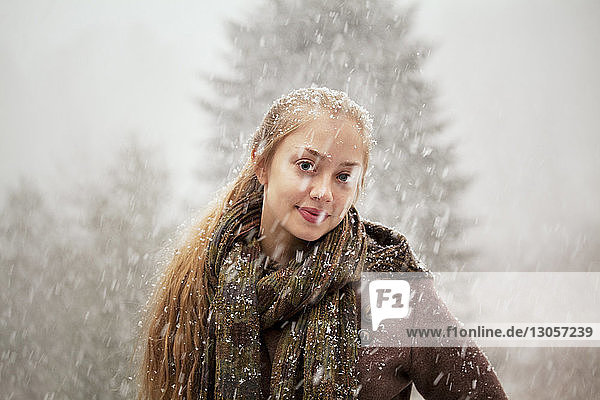 Portrait of happy woman in forest during winter