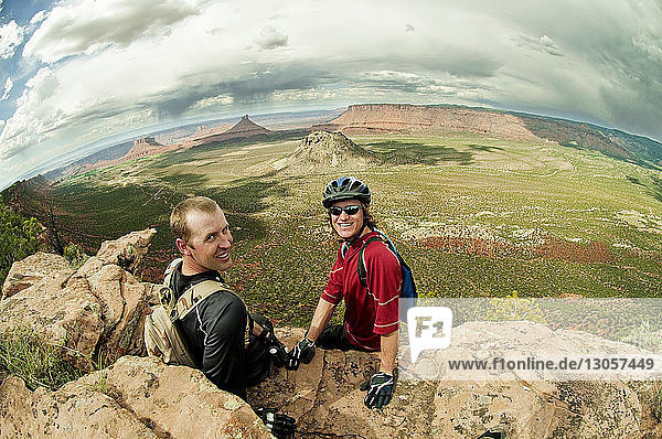 High angle view of mountain bikers sitting on rocks