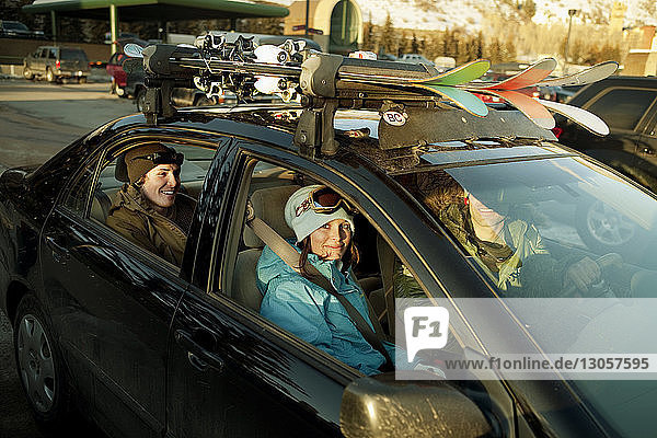 Glückliche Skifahrer sitzen im Auto