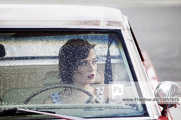 Frau schaut durch Fenster  während sie im Auto sitzt