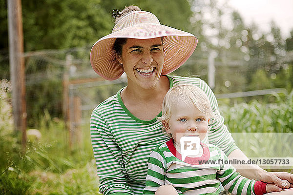 Porträt einer fröhlichen Frau mit Sohn auf dem Bauernhof