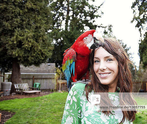 Portrait of beautiful woman with scarlet macaw