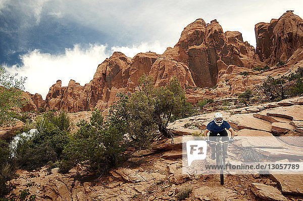 Mann fährt auf Felsen gegen Berge