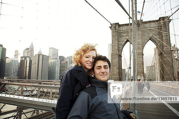 Porträt des glücklichen Paares auf der Brooklyn Bridge in der Stadt