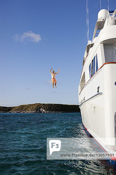 Man jumping from yacht in sea