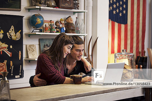 Paar benutzt Laptop-Computer  während es im Café sitzt