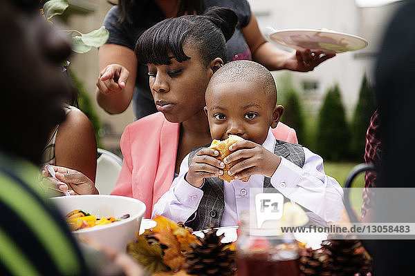 Mother and son eating food on picnic table