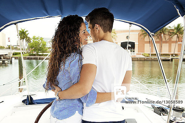 Paar umarmt sich  während es im Segelboot steht