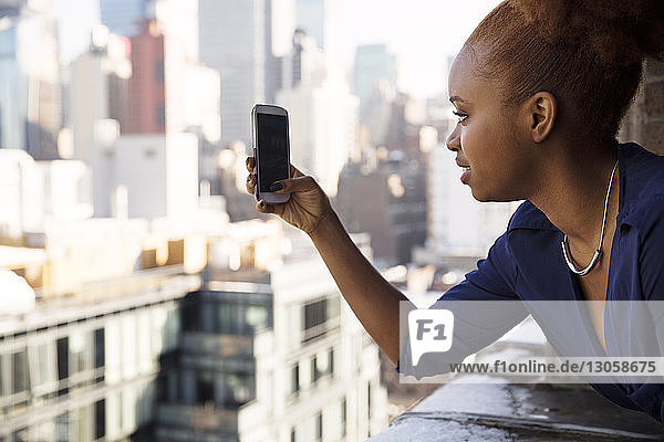 Geschäftsfrau fotografiert Stadt mit Smartphone