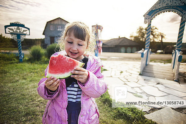 Happy girl eating watermelon at park